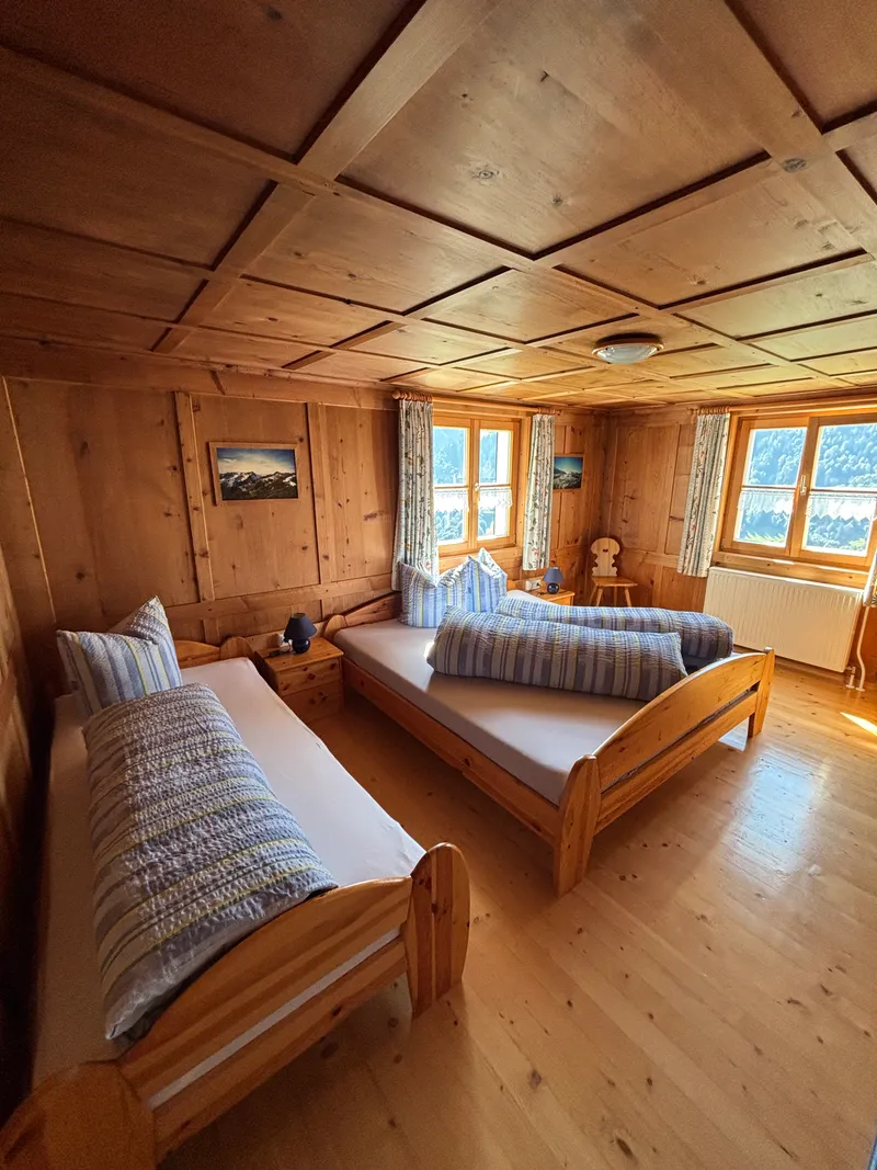 Schlafzimmer 1 mit Doppel- und Einzelbett im  Erdgeschoß - Haus Sücka - Ferienhaus Haus Sücka Blons, Großes Walsertal